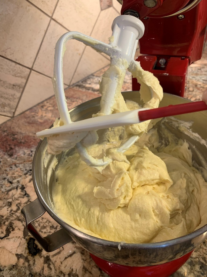 A person mixing batter with a silicone spatula. 